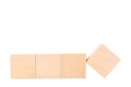 Four wooden cubes, one cube turned over. White isolated background. copyspace.