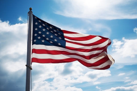 An American flag on a flagpole against a blue sky.