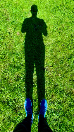 The shadow of a man on the green grasの写真素材