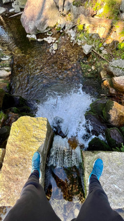 Tourist standing over a small cascading waterfall, Karkonosze Mountains, Polandの写真素材