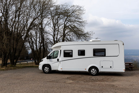 Camper van stands on the road against the backdrop of the Sudeten Mountains on the border between Poland and the Czech.の写真素材
