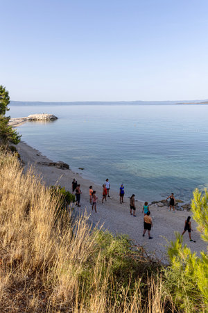 Makarska, Croatia July 22, 2925. People men and women on the beach in the evening in Croatia.