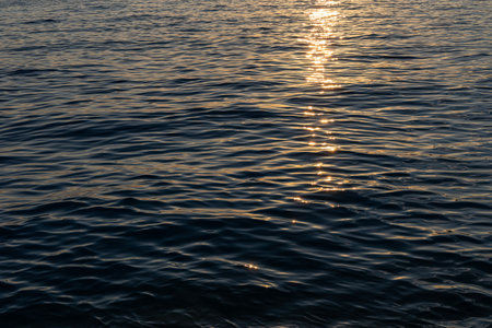 Sun reflecting on the evening sea, wavy sea surface. Marine background. Copy space.