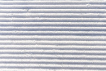 Snow groomed by a snowcat on a ski slope. Poland. Snow background.