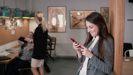 Young beautiful brunette woman uses a touchscreen tablet in the modern startup office team in the workplaceの写真素材