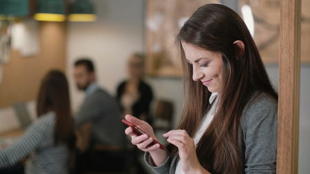 closeup attractive brunette businesswoman uses a touchscreen tablet in the modern startup office team in the workplaceの写真素材