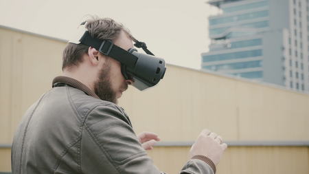 attractive man uses virtual reality glasses on the roof. 4kの写真素材