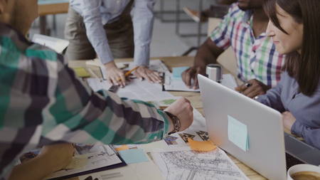 Creative business team discussing architectural project. Brainstorming of mixed race group of people in trendy office.の写真素材