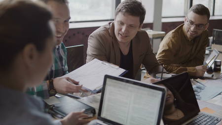 Young start-up company at trendy office. Multiethnic group of people discussing financial data use document and graphs.の写真素材