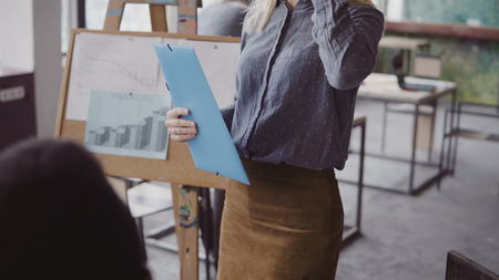 Close-up view of female manager walking through the office with documents. Multiracial team clap to businesswoman.の写真素材