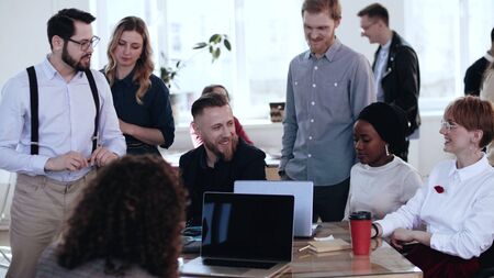 Happy multiethnic smiling group working together at loft office, brainstorming with middle aged boss at conference.の写真素材