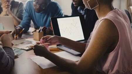Woman lays sticky note, holds pencil at meeting. Young multiethnic creative group brainstorming in modern office 4K.の写真素材
