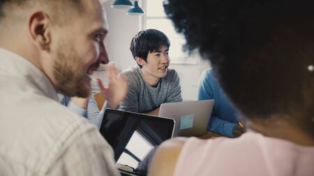 Multi ethnic group at office business meeting. Young diverse partners discuss ideas, then start clapping and smiling 4K.の写真素材