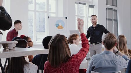 Happy middle aged coach businessman giving talk at modern office conference to multiethnic teamの写真素材