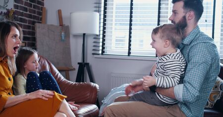 Family togetherness concept, young happy Caucasian parents play with children and having fun time at home slow motion.の写真素材