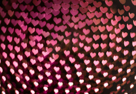 Small bokeh hearts on a dark background symbolizing love on Valentine's dayの写真素材