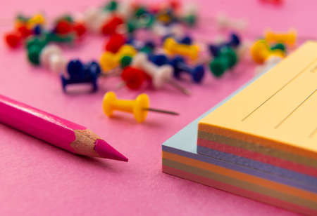 Pencil and Notepad for notes are on a colored background. Photo taken close-upの写真素材
