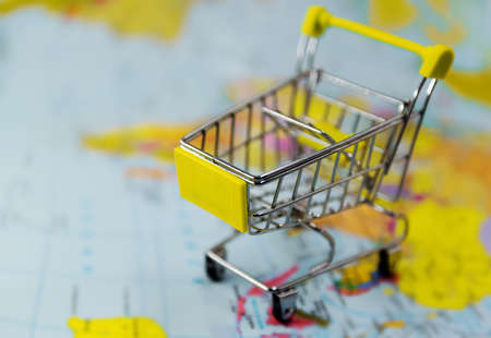 The shopping cart is on the map. Shopping around the worldの写真素材