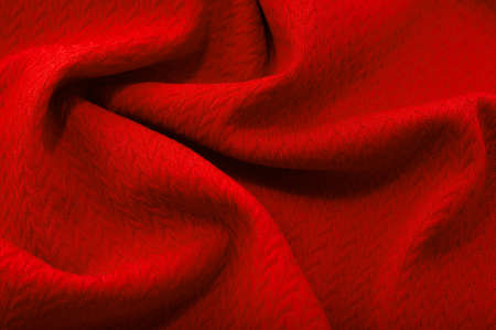 a piece of red cloth. fabric texture for background and design works of art, beautiful wrinkled pattern of silk or linen. A crumpled piece of clothの写真素材