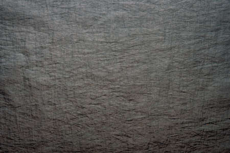 A piece of crumpled fabric of dark gray color.