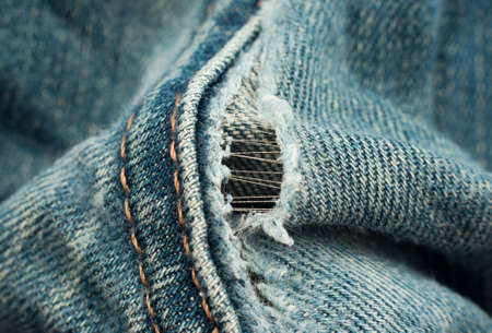 A hole in jeans close-up. Ripped holey jeansの写真素材