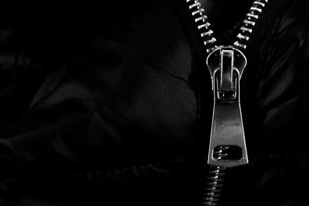 A lock with a silver zipper on a black background. Zipperの写真素材