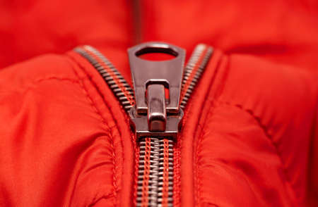 Close-up zipper on light red clothing, jacket. Zipper closure with lock.の写真素材