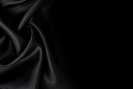 Part of the dark fabric texture of the fabric for the background and decoration of the work of art, a beautiful crumpled pattern of silk or linen. A crumpled piece of clothの写真素材