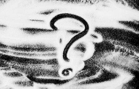 Question mark on a black background. Dark background made of flour, powder, semolinaの写真素材