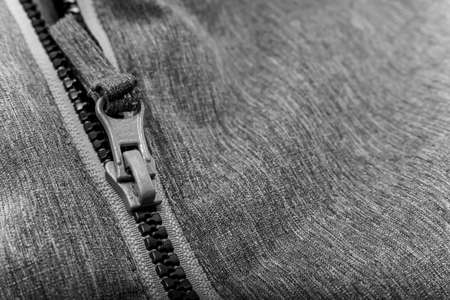 White lock with a zipper on gray clothes, jacket, jacket close-up. Lightning.の写真素材