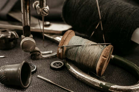 Retro tools for cutting and sewing. Needle with thread, thimble, sewing machine and scissorsの写真素材
