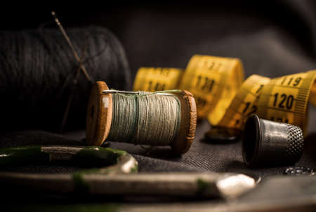 Retro tools for cutting and sewing. Needle with thread, thimble, centimeter and scissors. Tailor and seamstressの写真素材
