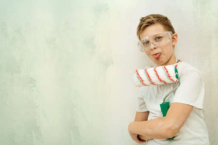 A young painter on the background of the wall. painting works. Construction and repair