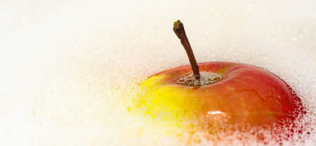 apple in water. The apple is washed and cleaned of dirt and dust in a soapy solution with bubbles