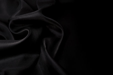 Part of the dark fabric texture of the fabric for the background and decoration of the work of art, a beautiful crumpled pattern of silk or linen. A crumpled piece of clothの写真素材