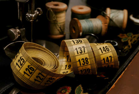 Vintage retro needle and thread, thimble and centimeter close-up. Tools for the work of a tailor,...