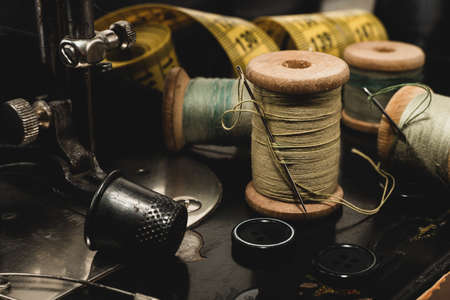 Retro tools for cutting and sewing. Needle with thread, thimble, sewing machine and scissorsの写真素材