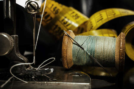Retro tools for cutting and sewing. Needle with thread, thimble, sewing machine and scissorsの写真素材