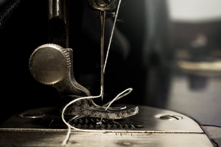 Retro tools for cutting and sewing. Needle with thread, thimble, sewing machine and scissorsの写真素材