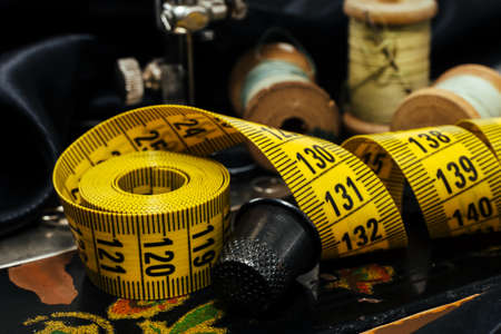 Retro tools for cutting and sewing. Needle with thread, thimble, sewing machine and scissorsの写真素材
