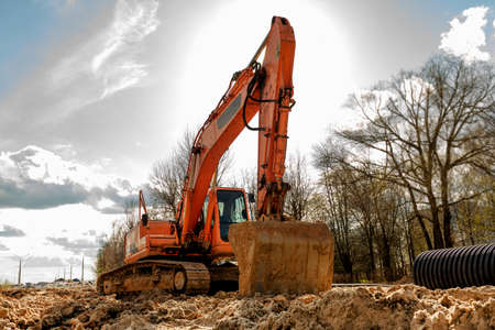 An excavator with a bucket digs a trench for laying pipes. construction vehicle. construction....
