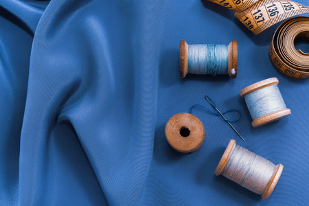 Vintage retro spool of thread on a black and white fabric background. Needle with threadの写真素材
