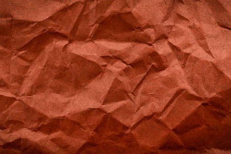 Background from crumpled brown color paper. Paper with scuffs and wavesの写真素材