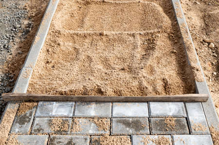 Laying the path with paving bricks. street improvement. Construction of pedestrian roads