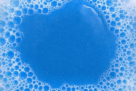 Soap foam. Background of dusty foam with bubbles of blue color for an inscription. Soap sud with...