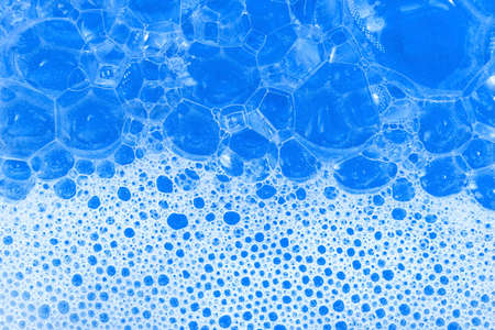 Soap foam. Background of dusty foam with bubbles of blue color for an inscription. Soap sud with copy-spaceの写真素材