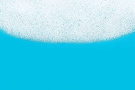 Soap foam. Background of dusty foam with bubbles of blue color for an inscription. Soap sud with...