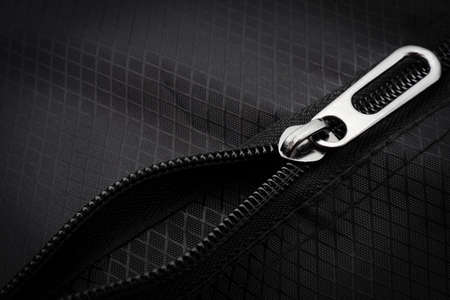 A lock with a silver zipper on a black background. Zipper