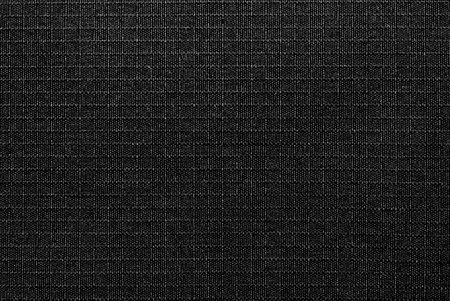 Textile. The material is gray or black in a small check. Fabric background with small squares....