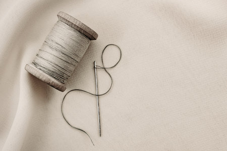 etro needle and thread lie on the fabric. Tools for a tailor or seamstress. black and white photographyの写真素材
